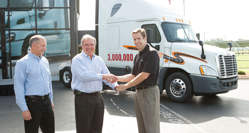 Roger Nielsen, Chief Operating Officer for Daimler Trucks North America (DTNA), and Richard Shearing, Vice President of National Accounts for DTNA, at the handover of the three-millionth produced commercial vehicle to Steve Duley, Vice President of Purchasing for “Schneider”, one of the largest logistics and transportation service companies in North America.