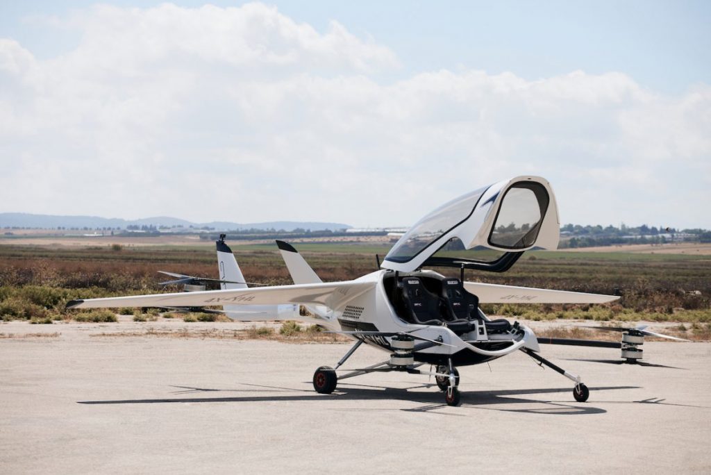 A white eVTOL on the ground with its cabin door open