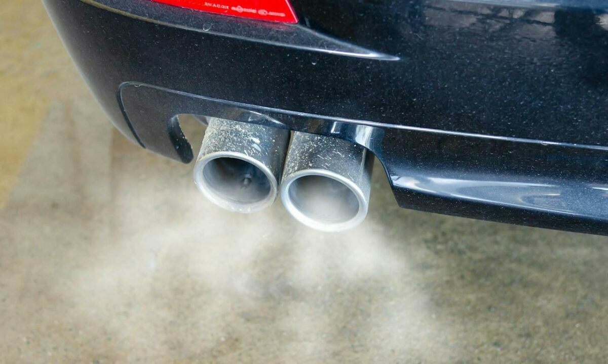The tailpipe of a car with smoke coming out of it